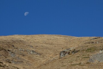 Fototapeta na wymiar Berglandschaft mit Mond am Tag.