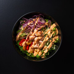 top view plate with mixed salad and shrimp on black background