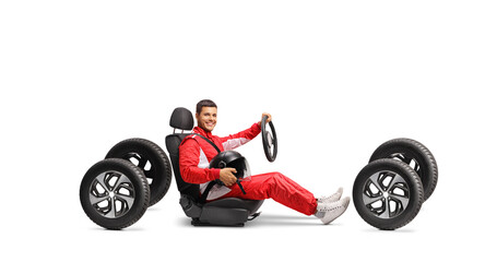 Racer in a car seat on four tires holding a helmet and a steering wheel