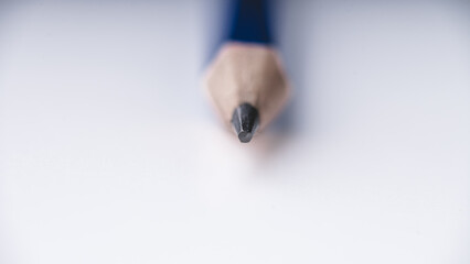 A pencil sits centered on a pristine white background, its details sharply defined in a close-up...