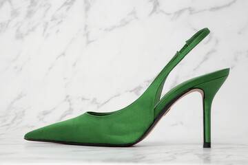 Creative studio shot of green satin slingbacks heels with the classy pointed toe, product...