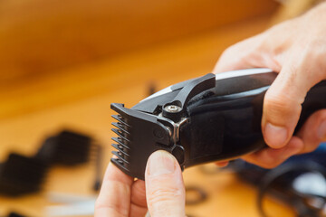 Hairdresser changing the comb of his hair clipper machine.