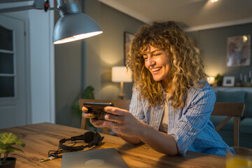 woman caucasian play video games on smartphone mobile phone at home