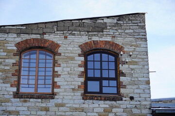 Close up of two windows on the side of a brick building