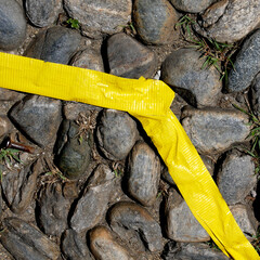 yellow tape on cobblestone street guiding visitors