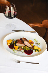 Food photography, delicious duck fillet on a large white plate. Restaurant, banquet, catering.