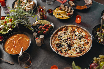 Cozy holiday table setting with different delicious food and beverages ready for friends home party