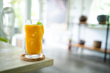 Fresh mango juice on table with luxury home blur background