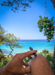 A man with cigar enjoying beautiful scenic view of turquoise sea on a sunny summer day.