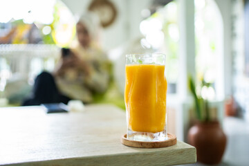 Fresh mango juice on table with luxury home blur background