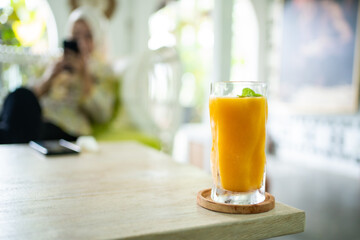 Fresh mango juice on table with luxury home blur background