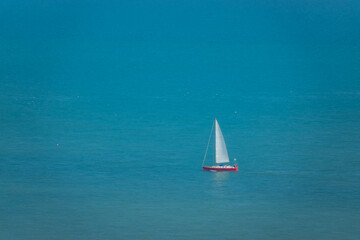 Sailboat sails gracefully across turquoise blue off the coast of South England