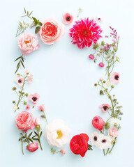 White flat lay with white, red and pink spring and summer flowers on it. View from the above