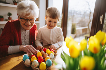 Grandma and grandchild enjoying Easter egg painting, in a warm home ambiance - obrazy, fototapety, plakaty