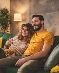 Couple caucasian man and woman sit at home on sofa bed watch tv movie