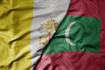 big waving national colorful flag of maldives and national flag of vatican city.