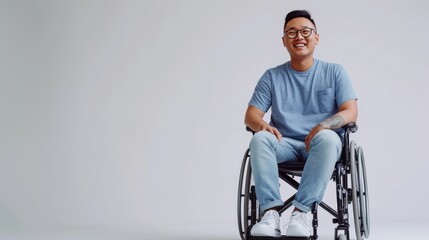 asian man with a physical disability smiling and sitting in a wheelchair dressed in jeans, a blue t-shirt, positioned against a white background, Fashion mockup, Lifestyle, Stylish studio background