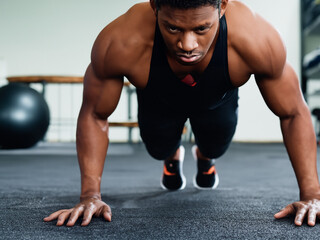 Obraz premium Athletic Man Doing Push Ups Training in Gym