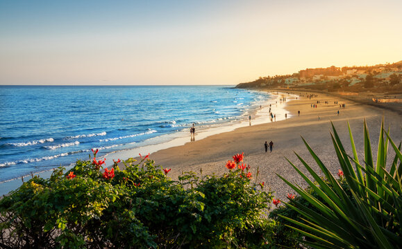 Costa Calma beach in the sunset light with people enjoying the summer vacation on the Atlantic Ocean coast in Fuerteventura Island in Canaries