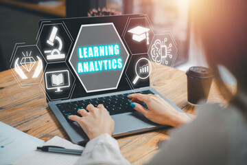 Learning analytics concept, Business woman using laptop computer on office desk with learning analytics icon on virtual screen.