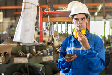 Industrial innovation with empowering of female engineer in factory setting, poised with tools of...