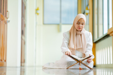 Ramadan, quran, The image of an Asian Muslim woman in the Islamic religion in hijab in cream color....