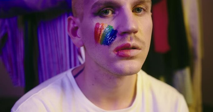 Portrait of LGBT Individual with Pride Flag on Cheek