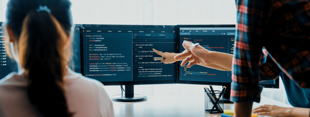 Young Professional website developer and cooperative computer engineer team brainstorming and sharing idea of program writing and coding at modern meeting room. Teamwork concept. Closeup. Burgeoning.