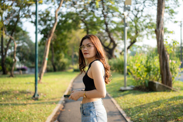 Naklejka premium Portrait of asian woman relax in city park sunset light sky