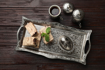 Tasty chocolate halva served on wooden table, flat lay