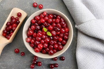 Fresh ripe cranberries in bowl and scoop on grey table, flat lay