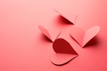 Paper hearts on red background, closeup. Space for text