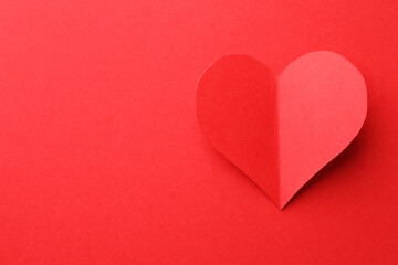 Obraz premium One paper heart on red background, top view. Space for text