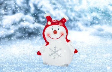 Cute decorative snowman outdoors on snowy day