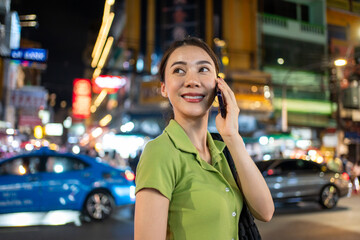 Asian attractive woman backpacker talking on phone while walk in city. 