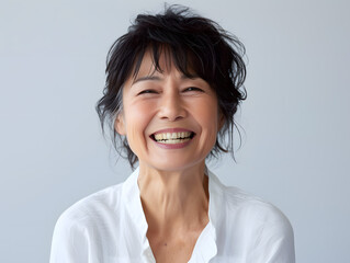 年齢を重ねても変わらぬ笑顔を咲かせる、アジア人シニア女性のポートレート - obrazy, fototapety, plakaty
