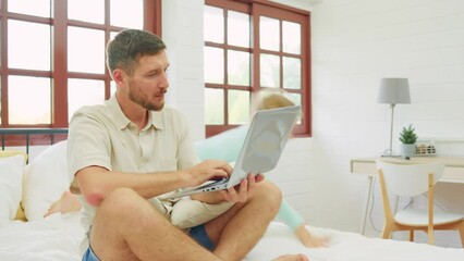 Caucasian father using laptop computer while daughter playing around.  - Powered by Adobe