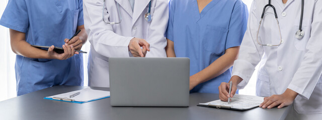 Doctor and nurse in medical meeting discussing strategic medical treatment plan together with report and laptop. Medical school workshop training concept in panoramic banner. Neoteric - obrazy, fototapety, plakaty