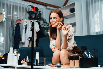 Woman influencer shoot live streaming vlog video review makeup utmost social media or blog. Happy young girl with cosmetics studio lighting for marketing recording session broadcasting online.