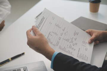 Close up view of job interview in office, focus on resume writing tips, employer reviewing good cv of prepared skilled applicant, recruiter considering application, hr manager making hiring decision