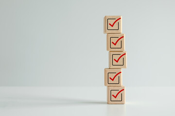 Checklist, Task list, Survey and assessment. Quality Control. Goal achievement and business success. Elections and Voting, Vote, to do list. Red correct check mark icon on stack of wooden blocks.