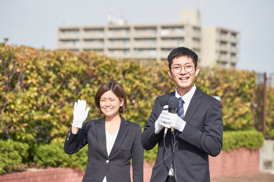 マイクを持っているスーツを着た男性と女性