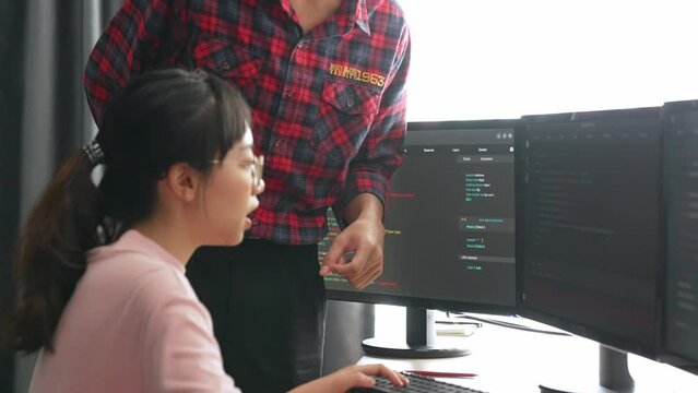 Slow motion back end or software developer manager supervising his team on new application program development on debugging and solving complex code algorithms on monitor. Burgeoning