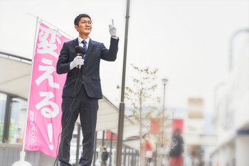街中で選挙活動をするスーツを着た男性