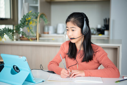 タブレットを見ながら勉強をしている小学生の女の子