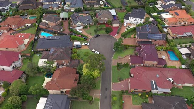 Reverse aerial flyover of upmarket homes, gardens and pools on a quiet cul-de-sac in outer suburban Sydney, Australia.