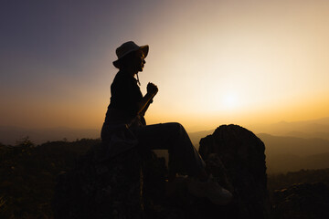 Silhouette of christian woman hand praying, Woman praying in the morning on the sunrise background....