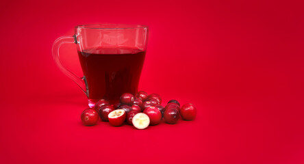 Fresh cranberries and cranberry juice against red