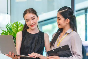 Portrait of smart young beautiful Asian business woman, successful female employee smiling with happy job, financial woman satisfied with the results of her work achievement in modern office