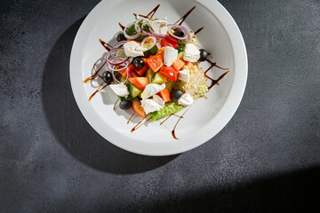 Overhead view of a traditional Greek salad with feta cheese and balsamic drizzle, a Mediterranean delight